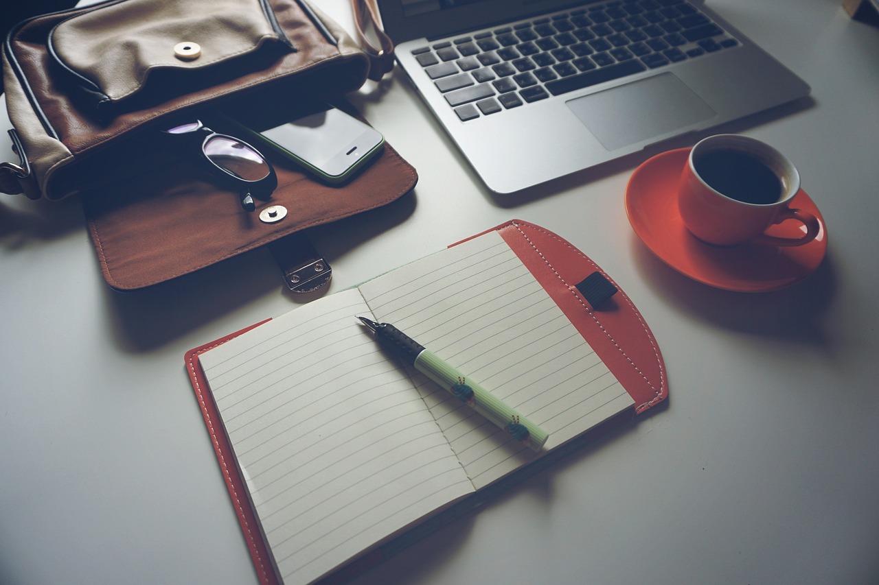 Laptop, coffee, notebook — The Essential Guide to Virtual Front Desk Software: Streamlining Operations and Enhancing Customer